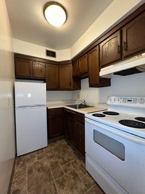 Glassport apartment for rent - an empty kitchen with white appliances and wooden cabinets