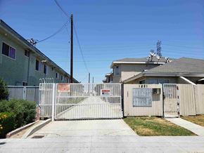 Long Beach apartment for rent - a yard with a white gate and fence in front of houses