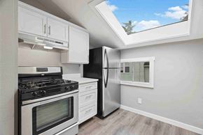 Tacoma apartment for rent - a white kitchen with stainless steel appliances and a window