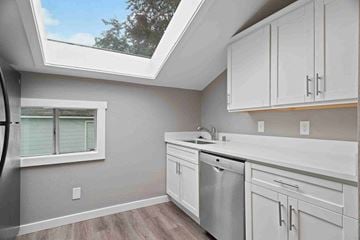 Tacoma apartment for rent - a kitchen with white cabinets and a sink and a window