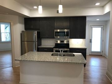 Saint Louis apartment for rent - A kitchen with a granite countertop and stainless steel appliances.