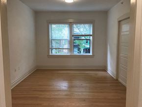 Saint Louis apartment for rent - A room with wooden floors and a window with blinds.