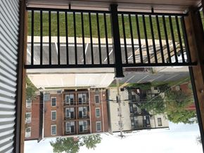 Saint Louis apartment for rent - A view from a window looking out at a parking lot and a building.