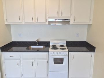 San Francisco apartment for rent - an empty kitchen with white cabinets and a stove and sink