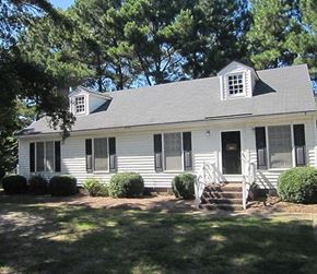 Wilson apartment for rent - A white house with a grey roof and a black door.