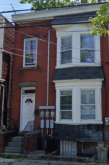 Newark apartment for rent - A red brick house with a white door and a window.