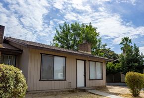 Merced house for rent - the front of a tan house with two doors