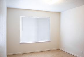 Merced house for rent - an empty room with a window and a tiled floor