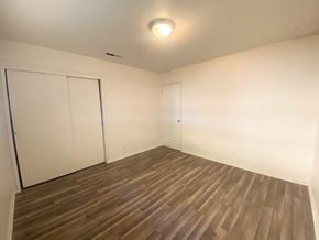 Merced house for rent - A room with a wooden floor and white walls.