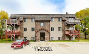 Grand Forks apartment for rent - a view of an apartment building with a red car parked in front