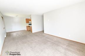 Grand Forks apartment for rent - an empty living room with white walls and carpet
