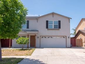 Merced house for rent - a white house with a driveway and a garage door