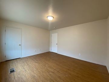 Merced house for rent - a living room with a wood floor and white walls