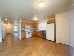 Merced house for rent - an empty kitchen with wood floors and white appliances