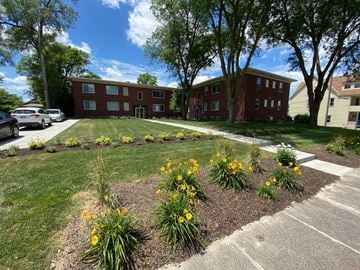 Omaha apartment for rent - A red brick building with a green lawn in front.