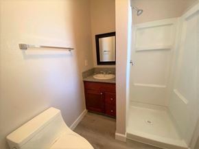 Merced house for rent - A white toilet is in a bathroom with a sink and a shower.