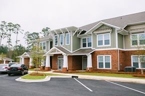 Thomasville apartment for rent - a large brick house with cars parked in a parking lot