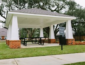 Thomasville apartment for rent - a gazebo with a picnic table and a sign on the grass