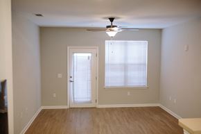 Valdosta apartment for rent - an empty living room with a ceiling fan and a window