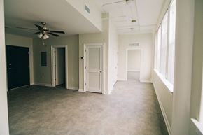 Pelham apartment for rent - an empty living room with a ceiling fan and windows