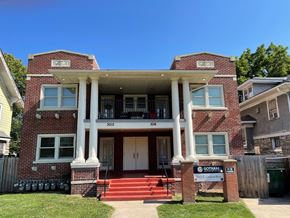 Kansas City apartment for rent - a red brick house with white pillars and a sign in front
