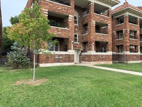 Kansas City apartment for rent - an apartment building with a lawn and a tree in front of it