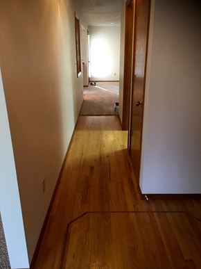 Tigard house for rent - a hallway with wooden floors and white walls