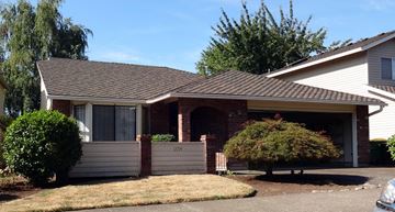 Tigard house for rent - a house with a garage and a tree in front of it