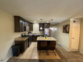 Omaha apartment for rent - a kitchen with a island with chairs and a sink