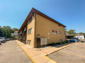 Omaha apartment for rent - a brick building with a sign on it on a sidewalk