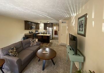 Omaha apartment for rent - a living room with a couch and a tv and a kitchen
