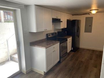 Richland apartment for rent - A kitchen with white cabinets and a black refrigerator.