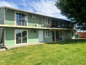 Kennewick apartment for rent - A green and white two story house with a lawn in front.