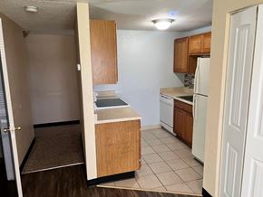 Kennewick apartment for rent - A kitchen with white appliances and wooden cabinets.