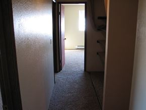 Kennewick apartment for rent - A hallway with a door on the left and a staircase on the right.
