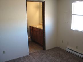 Kennewick apartment for rent - A bathroom with a sink and toilet is shown in a room with carpeting.