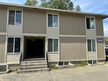 Pasco apartment for rent - A building with a beige exterior and a blue sign on the right side.