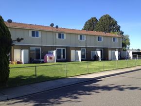 Kennewick apartment for rent - A row of houses with a fence in front.