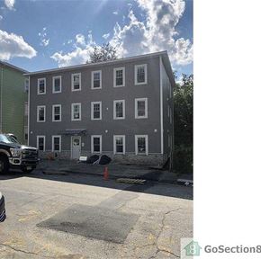 Worcester apartment for rent - A building with a grey facade and a white door is under construction.