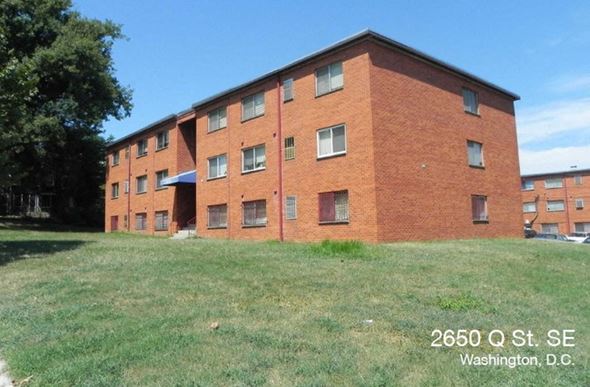 Washington apartment for rent - A red brick building with the address 2650 Q St. SE, Washington, D.C. on a sunny day.
