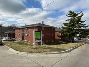 Omaha apartment for rent - Dunmore Creek Apartments is a brick building with a green sign in front.