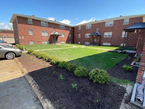 Omaha apartment for rent - A brick apartment building with a green lawn in front.