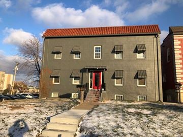 Omaha apartment for rent - a building with a red door and steps in the snow