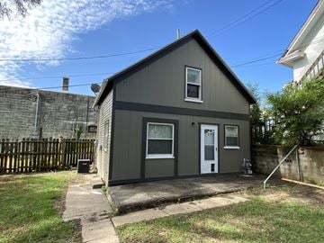 Omaha apartment for rent - the exterior of a small gray house with a white door