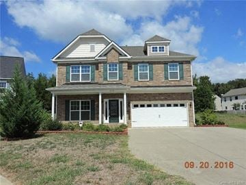 Charlotte house for rent - a large brick house with a white garage door