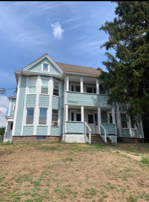 Manchester apartment for rent - an old house with blue and white siding and a lawn
