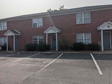 Shepherdsville apartment for rent - A red brick building with a parking lot in front.