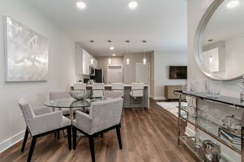 A living room and dining room with a glass table and chairs