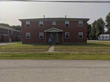 Louisville apartment for rent - A red brick building with a white door and windows.