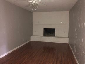 Snyder house for rent - a living room with a white brick fireplace and wood floors